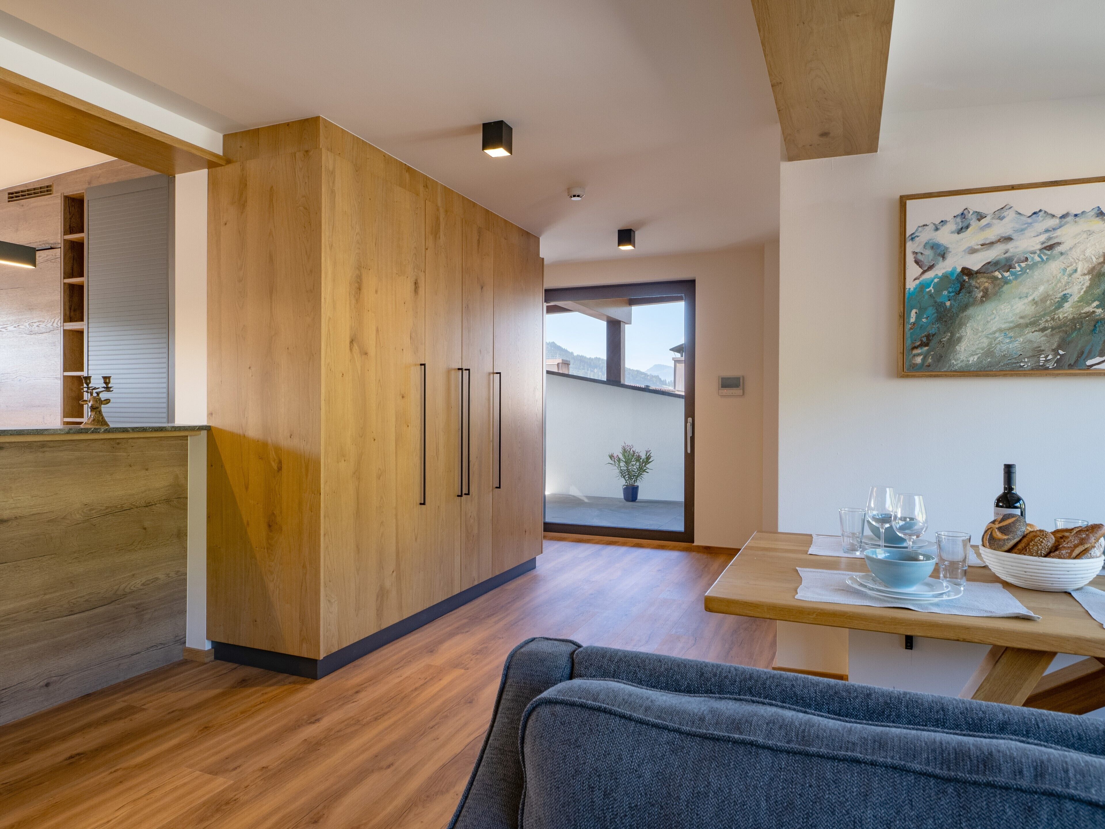 Eine moderne Küche mit Holzschränken und einem Essbereich mit Tisch für zwei Personen.