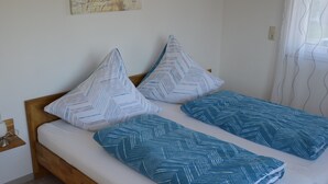 A bed with two pillows and a blue blanket. - Beautiful vacation apartment in the idyllic Allgäu (Altusried)