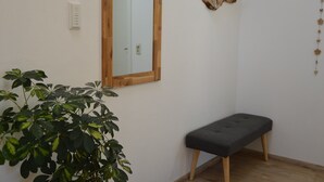 A room with a wooden bench, a mirror, and a potted plant. - Beautiful vacation apartment in the idyllic Allgäu (Altusried)