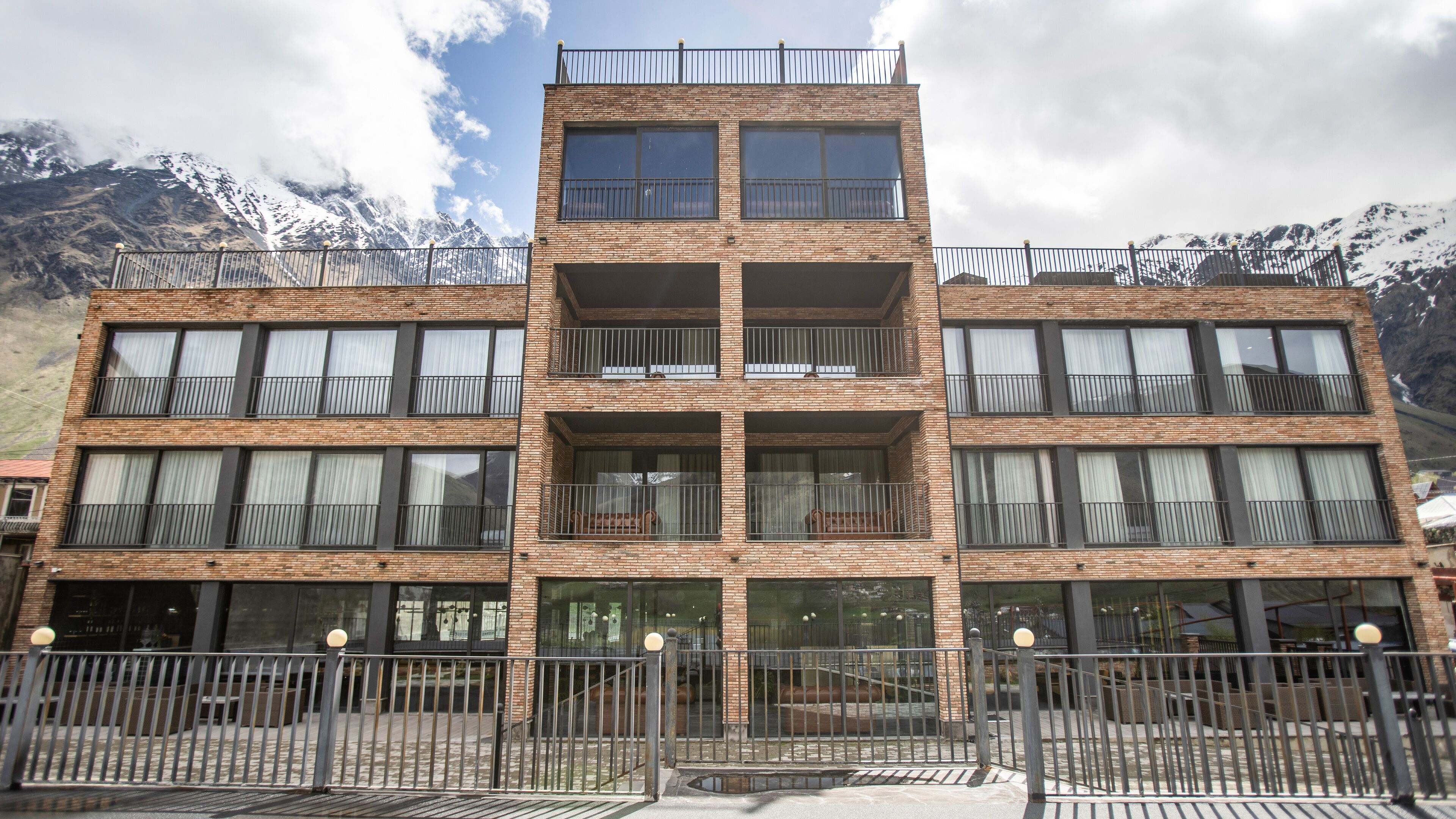 A multi-story hotel with a brick facade, large windows, and balconies.