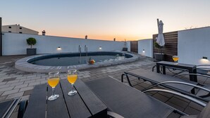 A rooftop pool area with a circular pool, two lounge chairs, and two glasses of orange beverage. - Villa Sea Pearl (Jasenice)