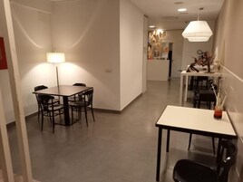 A modern dining area with a table and chairs, a lamp, and a decorative vase.