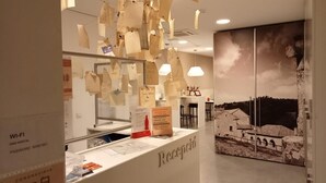 A reception desk with a sign reading "Recepción" and a wall with a historical painting.