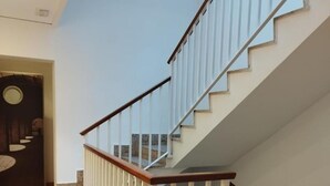 Una escalera moderna con barandillas de madera y balaustres blancos, que conduce a un piso superior.