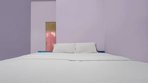 A bedroom with a bed, a nightstand, and a wardrobe.