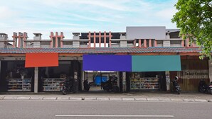 A building with multiple storefronts, including a visible sign for 'Colour Creators'.