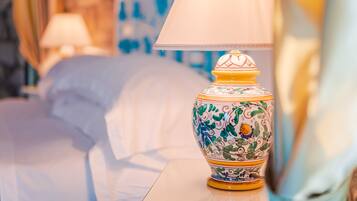 Una lampada decorativa con motivo floreale su un comodino in una camera d'albergo.