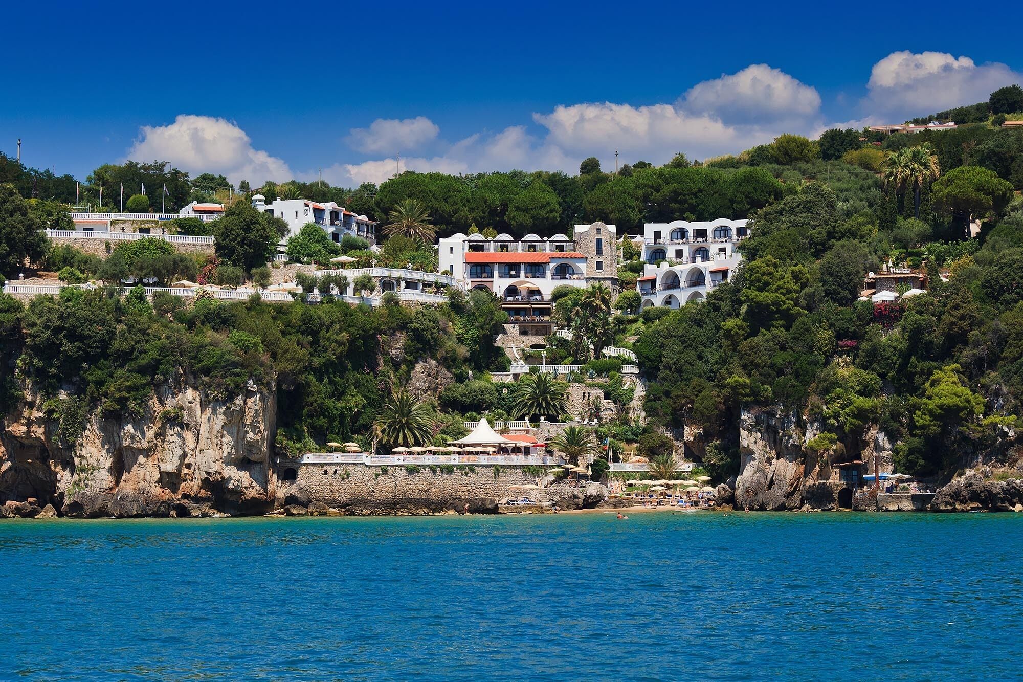 A coastal town with buildings on a hillside overlooking the sea.