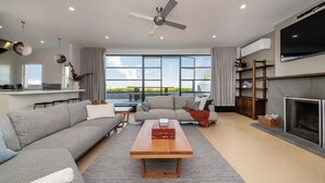 A modern living room with a sofa, a coffee table, and a fireplace. - Pet Friendly - Penthouse with City Views on Chapel (St Kilda)