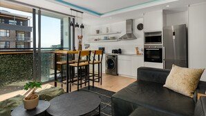 A modern apartment with a kitchen, dining area, and living room. - The Iron Works 611 (Cape Town)