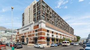 A multi-story building with a brick facade and large windows. - The Iron Works 611 (Cape Town)