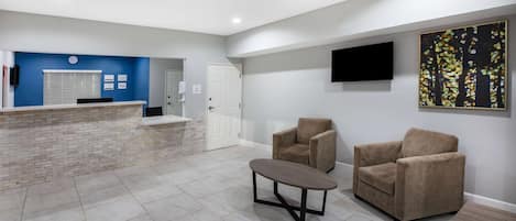 A reception area with a blue wall, a white door, and a flat-screen TV mounted on the wall.