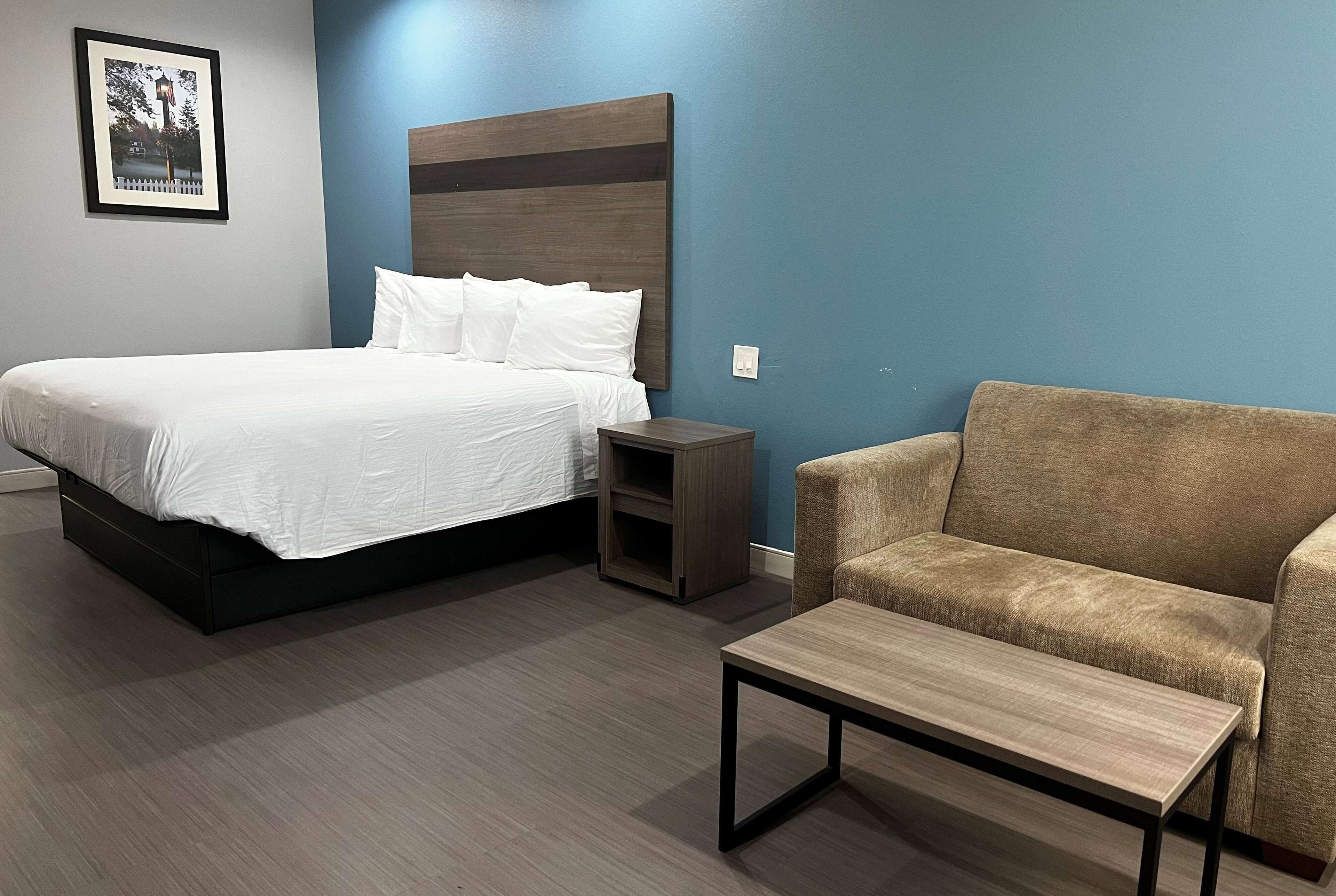 Une chambre à coucher avec un lit, une table de chevet et un canapé.
