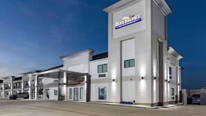 A modern hotel with a prominent Baymont sign, multiple floors, and a covered parking area.