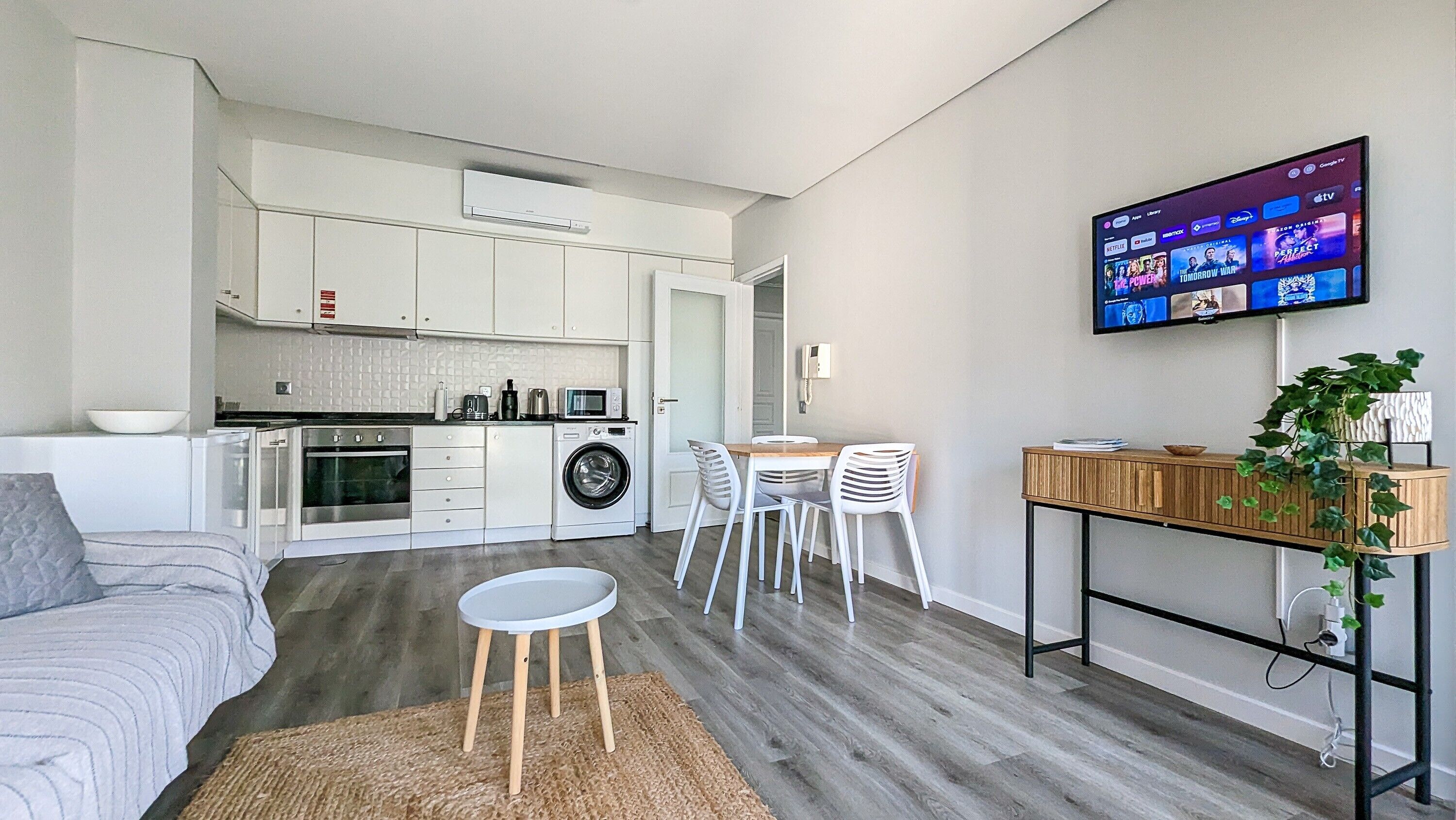 Un appartement moderne doté d’une cuisine, d’un coin repas et d’un téléviseur permettant d’accéder aux services de diffusion en continu.