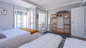 Una camera d'albergo con due letti, un armadio, una scrivania e una finestra.