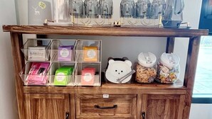 A wooden cabinet with transparent storage boxes containing various items, a glassware holder, and a bear-shaped container. - House in field (Dongshan)