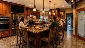 A kitchen with wooden cabinets, stainless steel appliances, and a marble island with seating.