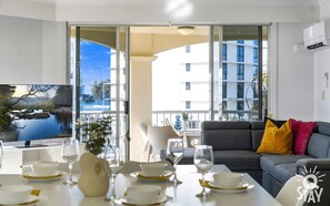 Relax in this stylish living room with a sofa, flat-screen TV, and dining area offering a view of the city.