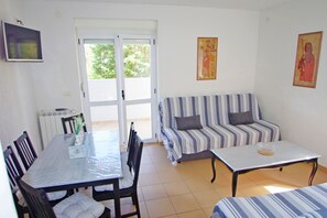 Un espace de vie comprenant une table à manger, un canapé à rayures et une table basse.