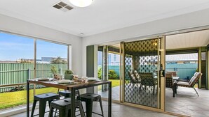 A modern room with a large sliding glass door leading to an outdoor patio area. - Sellicks Seascape by Wine Coast Holiday Rentals (SELLICKS BEACH)