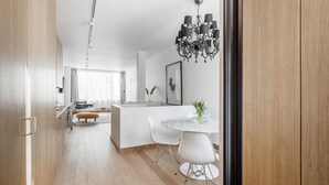 Una cocina moderna con armarios de madera, encimera blanca y una araña.