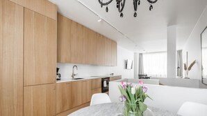 Una cocina moderna con armarios de madera, encimera de mármol y un jarrón de tulipanes.