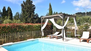 A pool with a wooden pergola and two lounge chairs. - Villa con Excelente Piscina (Sóller)