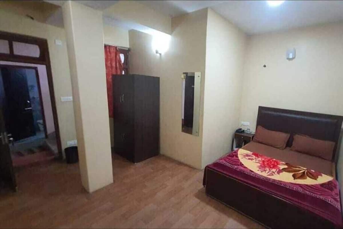 A bedroom with a bed, a wardrobe, and a mirror on the wall.