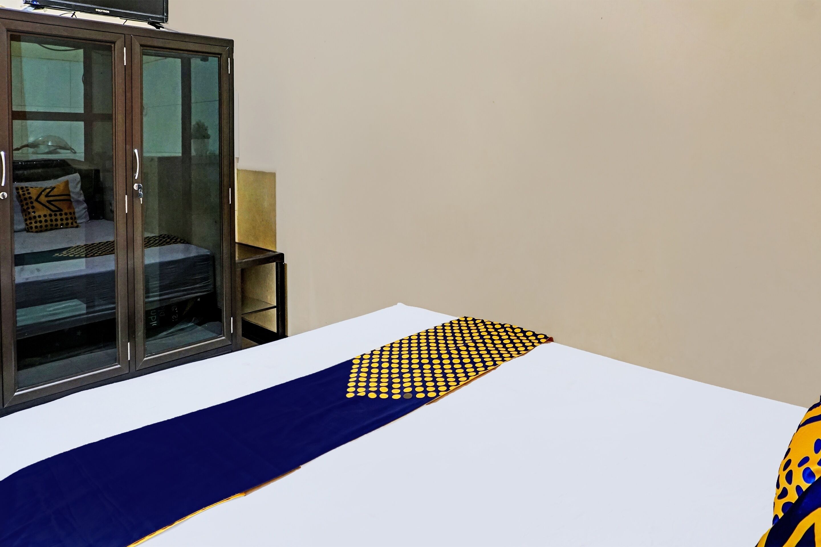 A hotel room with a bed, a wardrobe, and a window.