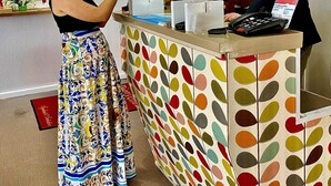 Una recepción con un estampado de lunares de colores, una lámpara y un teléfono.