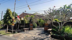 A traditional gate with a patterned floor leading to a house with a tiled roof. - Jero Harum Homestay (Tabanan)