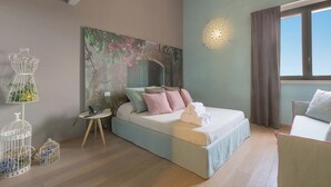 Une chambre à coucher comprenant un lit, une table de chevet, une lampe, des éléments de décoration murale et une fenêtre avec des rideaux.