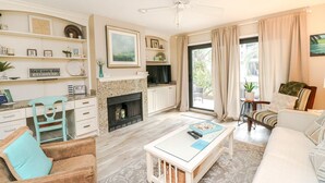 Un salon spacieux doté d’une cheminée, d’un coin repas et d’un espace détente avec un canapé et des fauteuils.