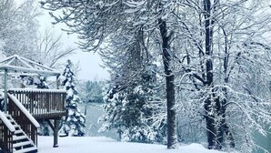 Una terrassa coberta de neu amb una escala de fusta que condueix a una glorieta.