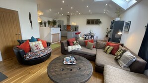 Ein modernes Wohnzimmer mit Holzboden, zwei Sofas, einem Couchtisch und einem Oberlicht.