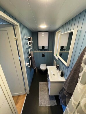 Ein kleines Badezimmer mit Toilette, Waschbecken und Handtuchhalter.