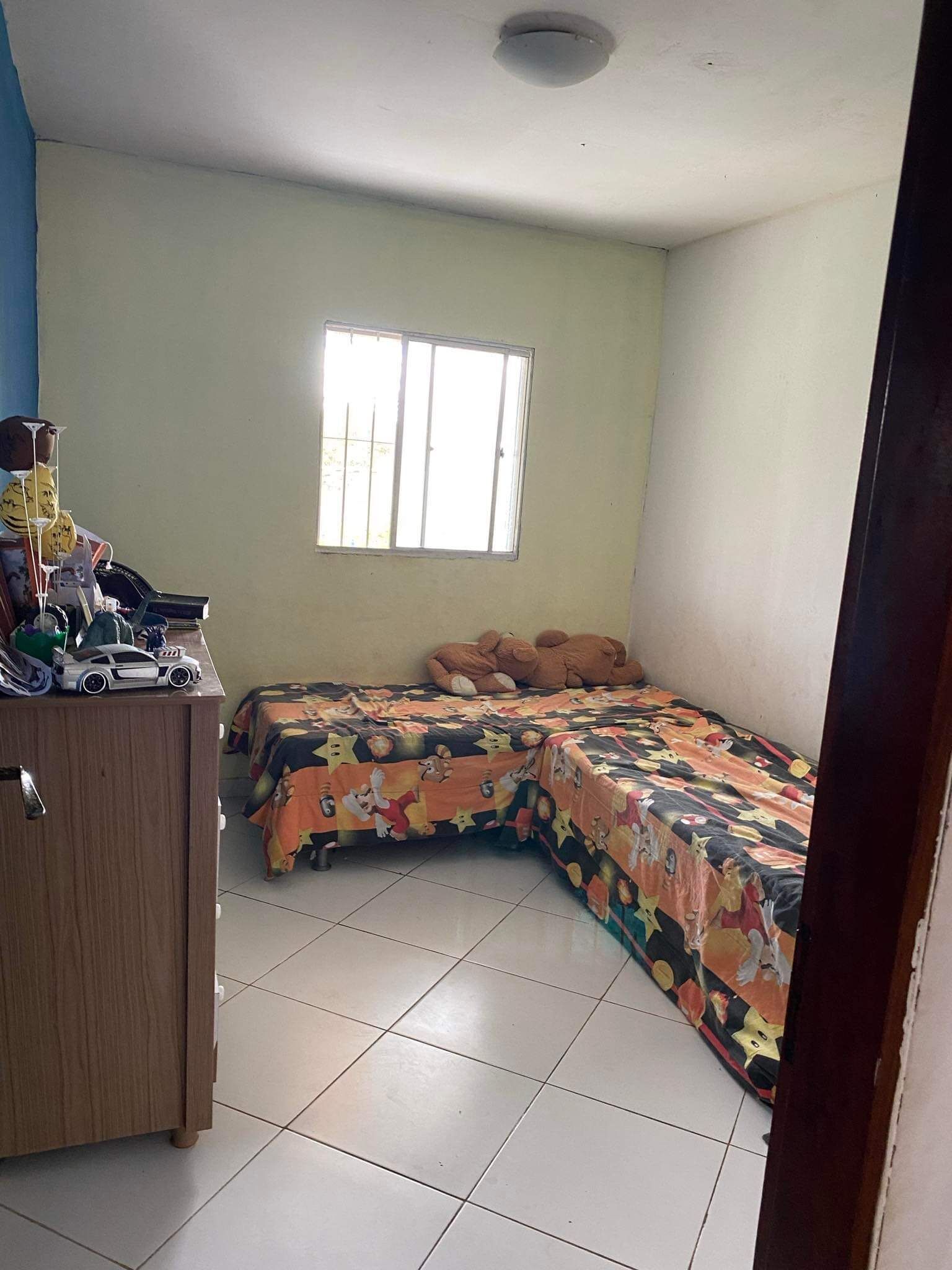 Una habitación con dos camas, una ventana y un armario de madera.