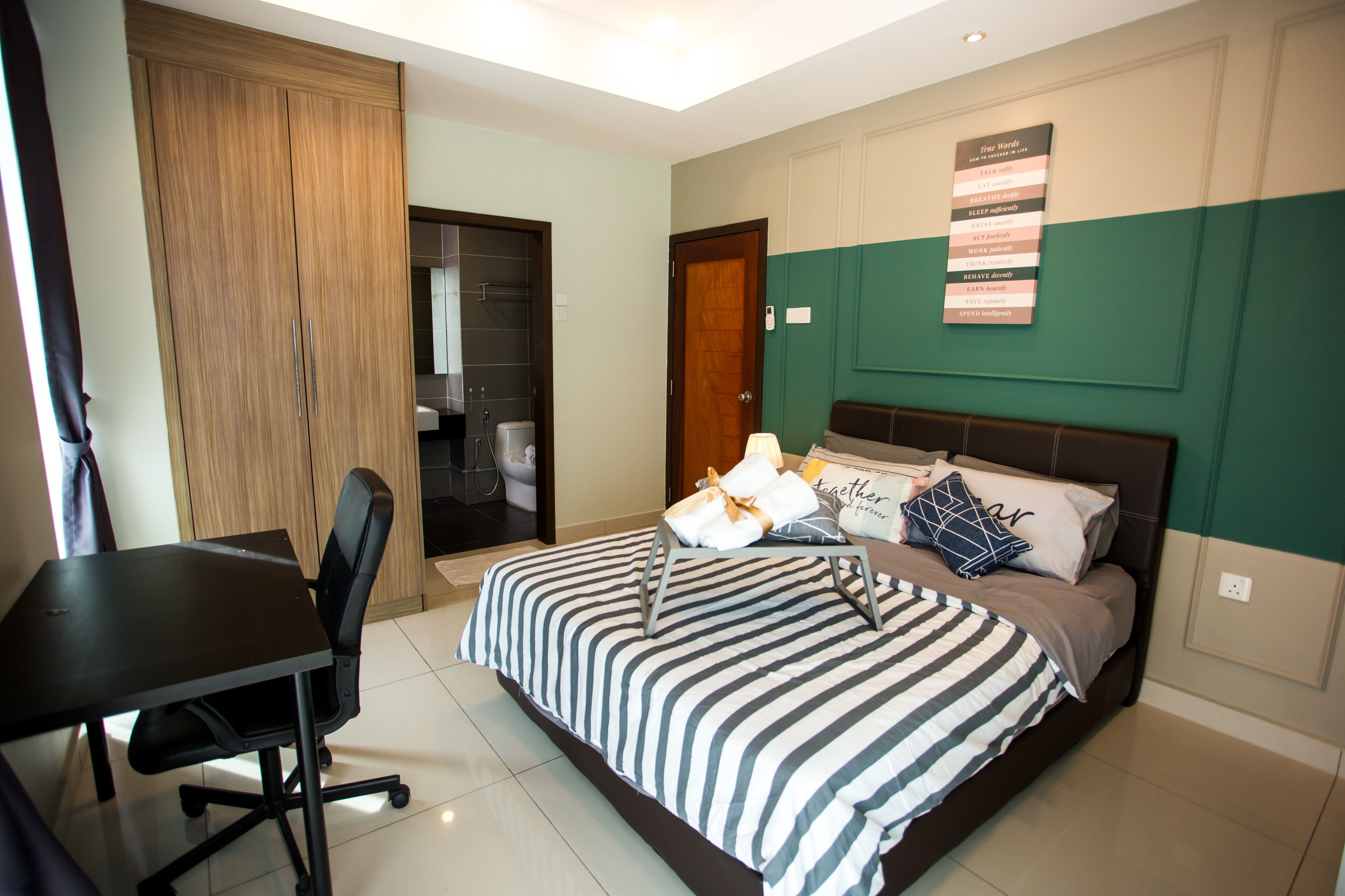 Un dormitorio con una cama, un escritorio y una silla.