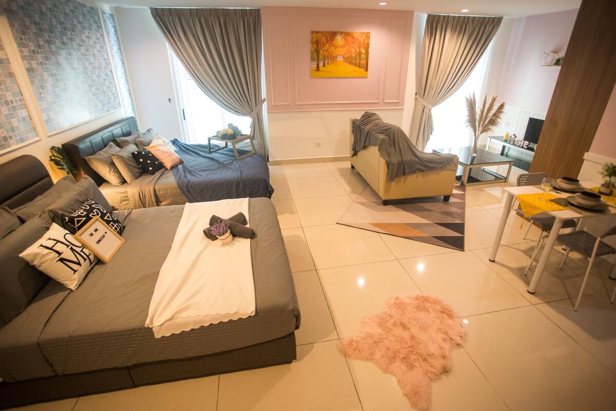 A modern living room with a sofa, a coffee table, and a dining area with chairs.