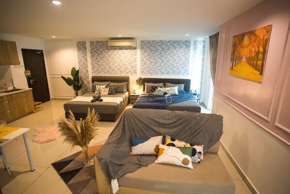 A modern living room with a sofa, a dining table, and a kitchen area.
