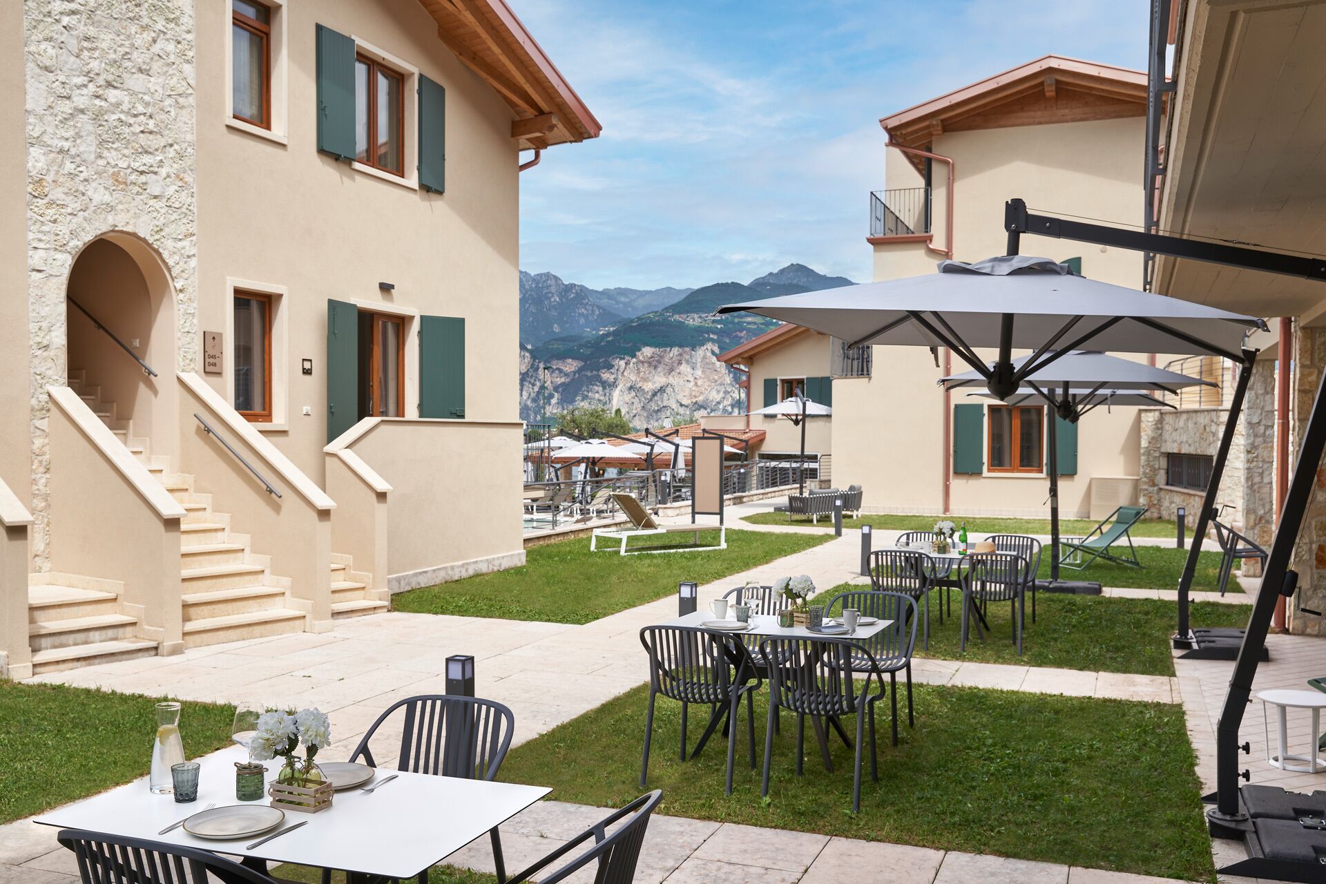 A courtyard with outdoor seating, a staircase, and mountain views.