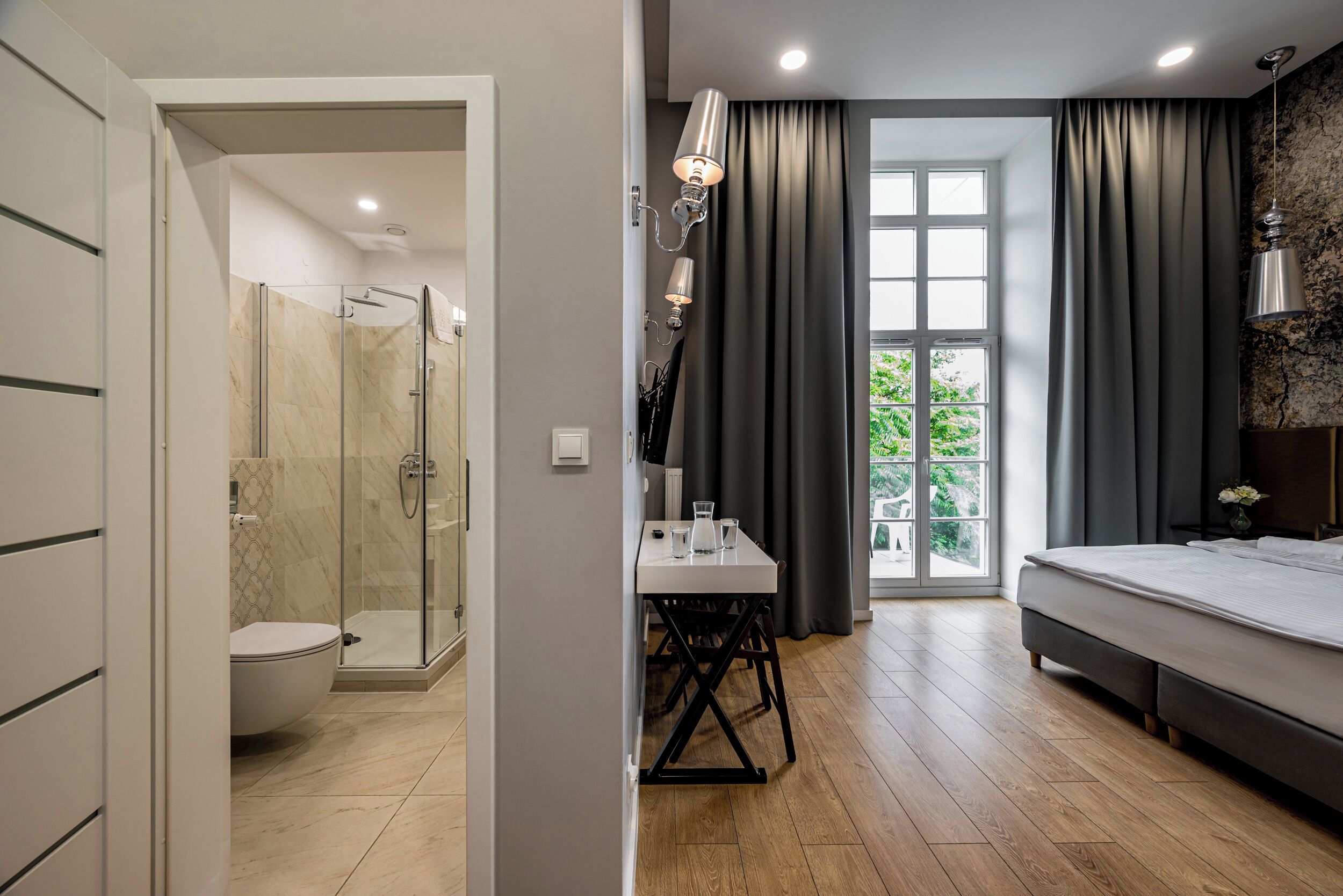 Ein modernes Badezimmer mit einer gläsernen Duschkabine, einer Toilette und einem Waschbecken mit Spiegel.
