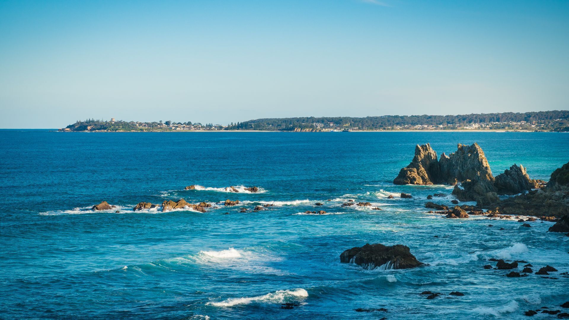 Un paysage côtier caractérisé par des affleurements rocheux et offrant une vue dégagée sur la mer.