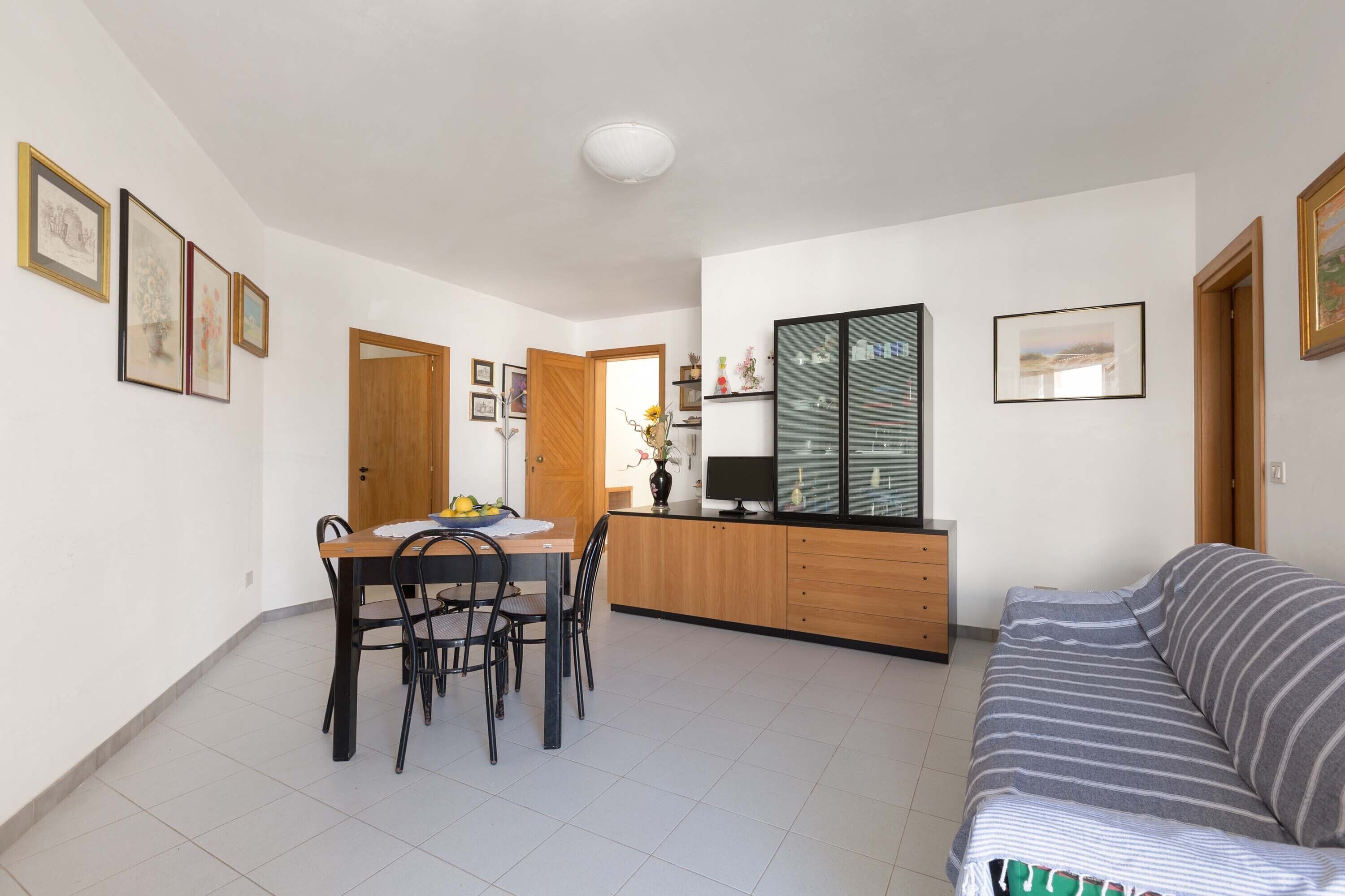 Un espace de vie compact comprenant un coin repas, une kitchenette et un canapé.