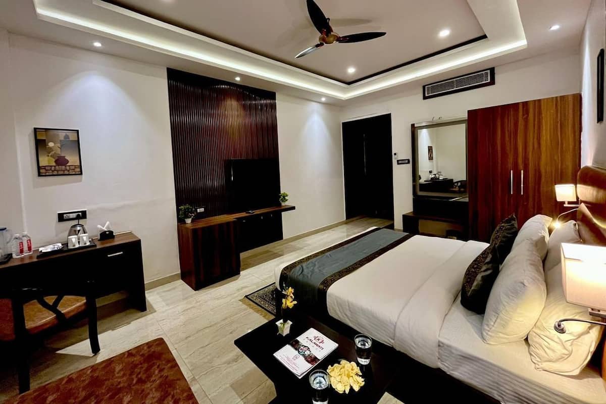 A modern hotel room with a bed, desk, and TV.