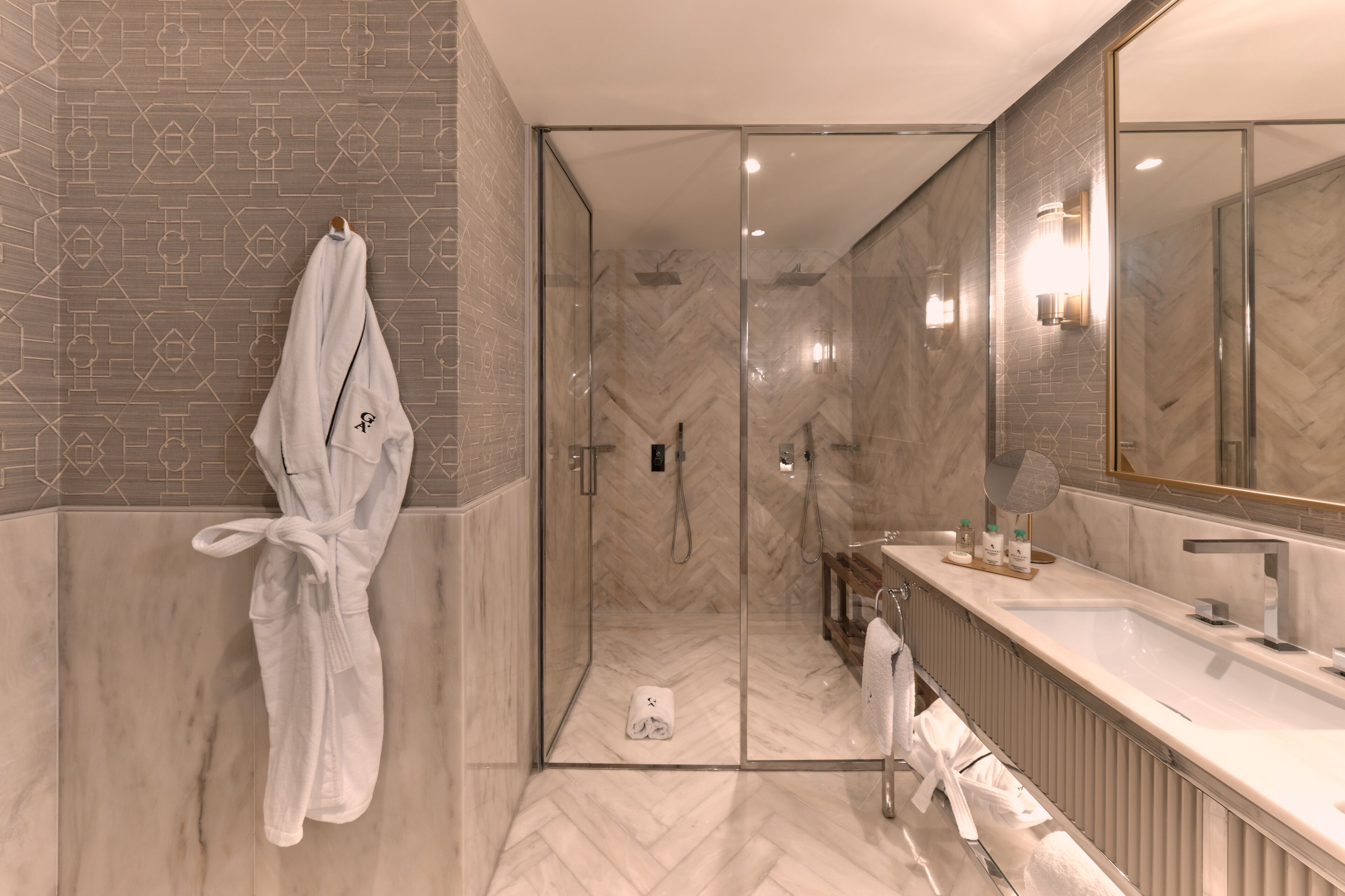 Deluxe studio suite | Badkamer | Een douche, designer toiletartikelen, een haardroger, badjassen