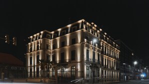 Un hotel histórico con una fachada clásica, varios pisos y una entrada destacada.