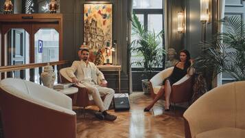 A spacious lobby with modern furniture, a large window, and a decorative painting.