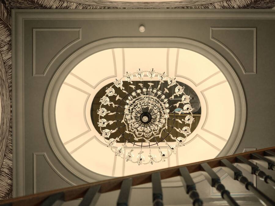 A grand, ornate ceiling with a circular skylight and a decorative chandelier.